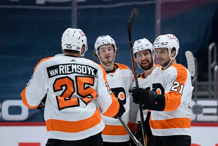 Flyers left wing Scott Laughton (21) celebrates his goal with left wing James van Riemsdyk (25), defenseman Erik Gustafsson (56) and left wing Joel Farabee during the first period.