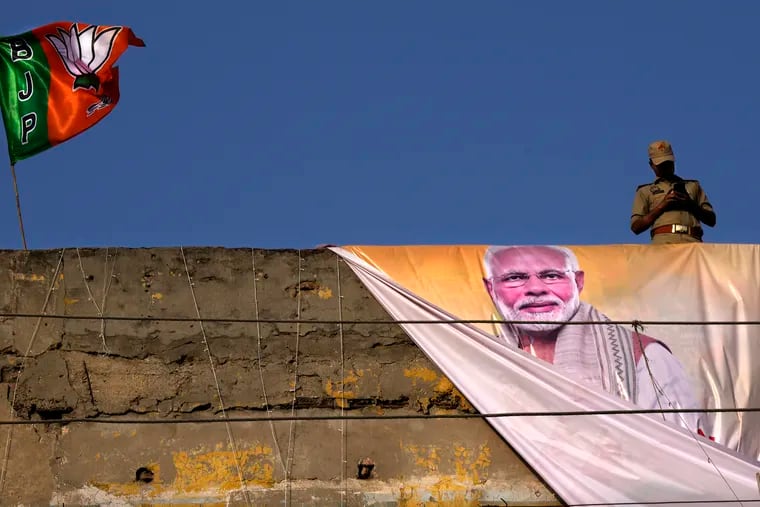 A policeman keeps watch from the roof of a building during a campaign rally by Indian Prime Minister Narendra Modi for his Bharatiya Janata Party (BJP) ahead of parliamentary elections in Ghaziabad, India, April 6, 2024. Modi is campaigning for a third term in the general election starting Friday.