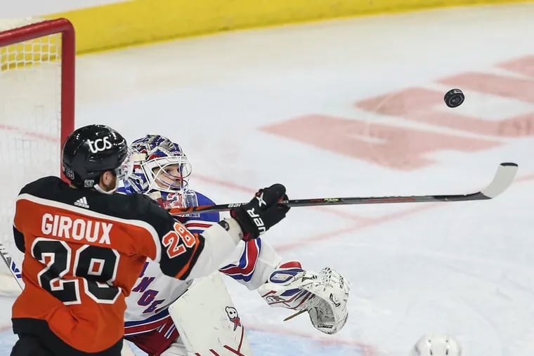 Flyers captain Claude Giroux tries to bring the puck down in front of Rangers goalie Igor Shesterkin during the first period Wednesday. Giroux put eight shots on goal and had three assists in his return from contracting the coronavirus.