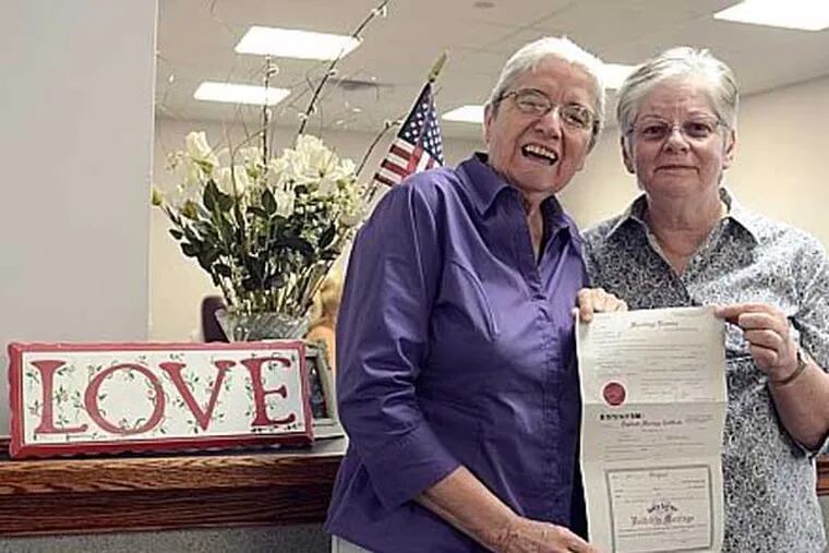 File photo: Peg Welch (right) and Delma Welch, pose with their newly-issued marriage license in the Norristown office July 31, 2013. Together for 23 years, the Welches drove in from York for the licence. They were married in Toronto in 2004 and have been waiting to get married in Pennsylvania. Their wedding was to be later in the evening in York. ( TOM GRALISH / Staff Photographer )