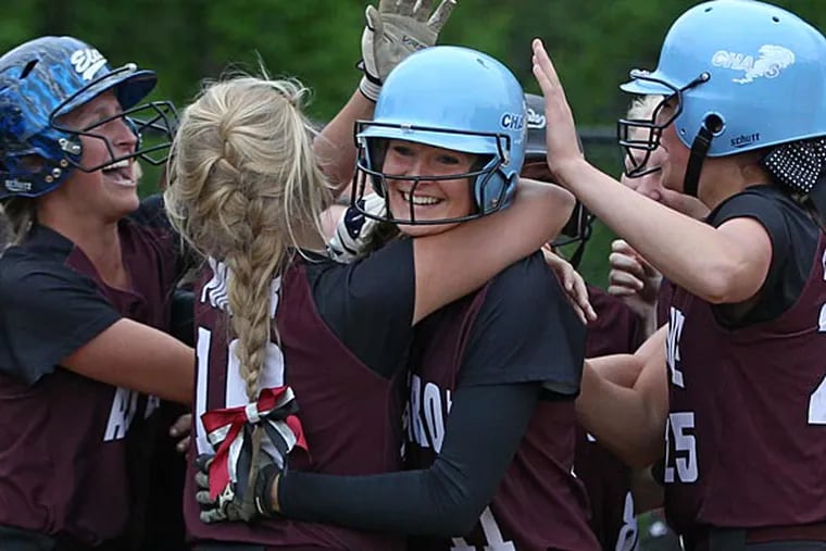 Avon Grove's #11, Alyssa Herion, center, is mobbed by her teammates as
she crosses home plate after a two run home run that tied the score
2-2 in the bottom of the first inning.  Avon Grove beats North Penn
4-2 to win the Class AAAA softball championship on Thursday at Great
Valley.  05/28/2014 ( Michael Bryant / Staff Photographer )
