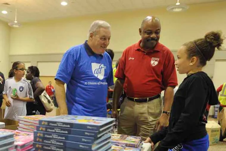 AFT-PA President Ted Kirsch (left) and PFT President Jerry Jordan talk with Mikalya McDonnell, a fifth grader at New Foundations Charter school, who was there with her mother, a third grade teacher, to pick up free text books handed out by the PFT and AFT at Steamfitters Local 420 in the Northeast in September 2013.