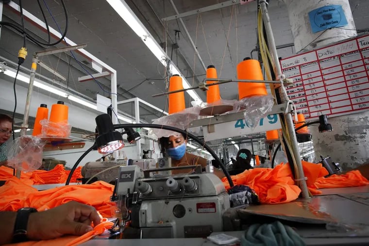 American Apparel garment workers are busy at work inside the Los Angeles headquarters, manufacturing operations center in 2014. Wages for workers at the low and high-end of the economy have grown while the middle has been stagnant.