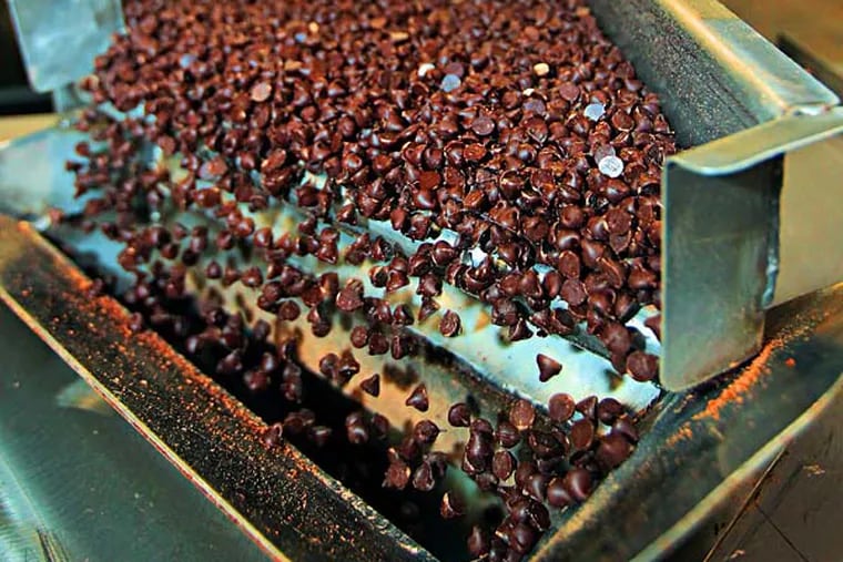 Thousands of chocolate chips fall off the converyor belt and into a hopper that will feed them into packing boxes that hold 50 pounds of the chocolate chips that Blommer makes. The nation's largest processor of chocolate beans (200,000 metric tons a year) has a huge factory in East Greenville. Demand for chocolate is up worldwide, but chocolate manufacturers are worried that demand may outstrip the supply of cocoa beans. Please refer to Leadership Agenda profile on company president Peter Blommer  04/10/2014  ( MICHAEL BRYANT / Staff Photographer )