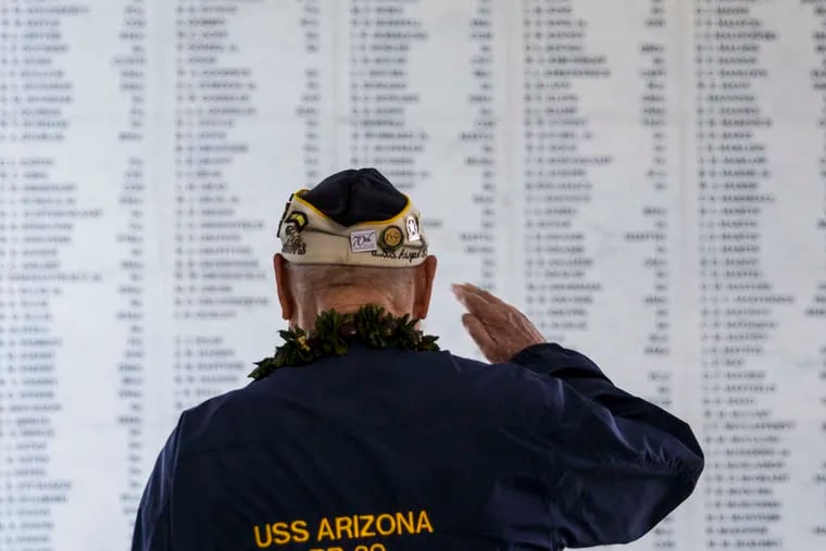 Survivor Louis Conter salutes the remembrance wall of the USS Arizona during a memorial service for the 73d anniversary of the attack that launched the United States into World War II. KENT NISHIMURA / Getty Images