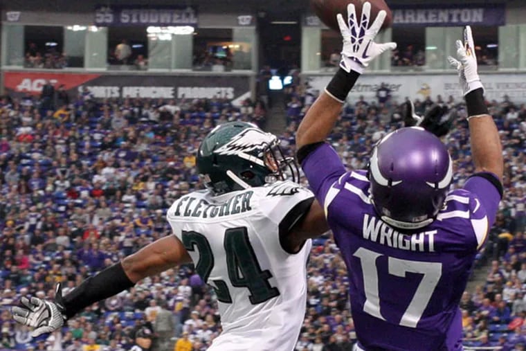 The Vikings' Jarius Wright catches the ball over Bradley Fletcher in the third quarter. (Yong Kim/Staff Photographer)