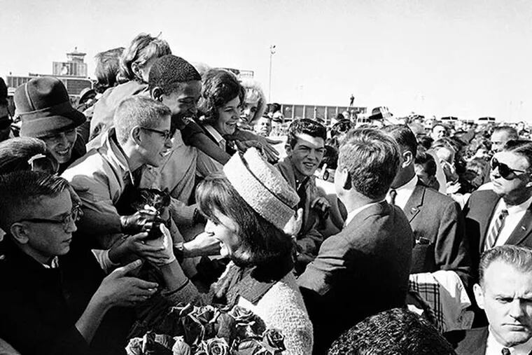 In this Nov. 22, 1963 file photo, President John F. Kennedy and first lady Jacqueline Kennedy greet people on their arrival at the Dallas Airport (Love Field). (AP Photo/HWB, File)