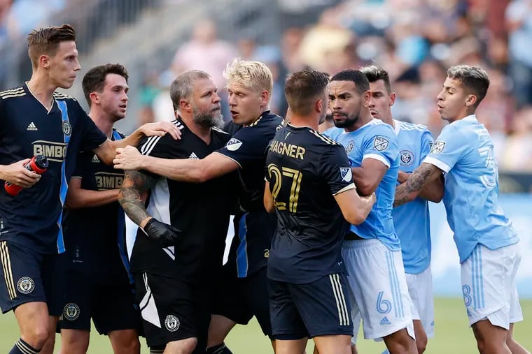 Union athletic trainer Paul Rushing (third from right) is held back by team members during the altercation with New York City FC on Sunday.