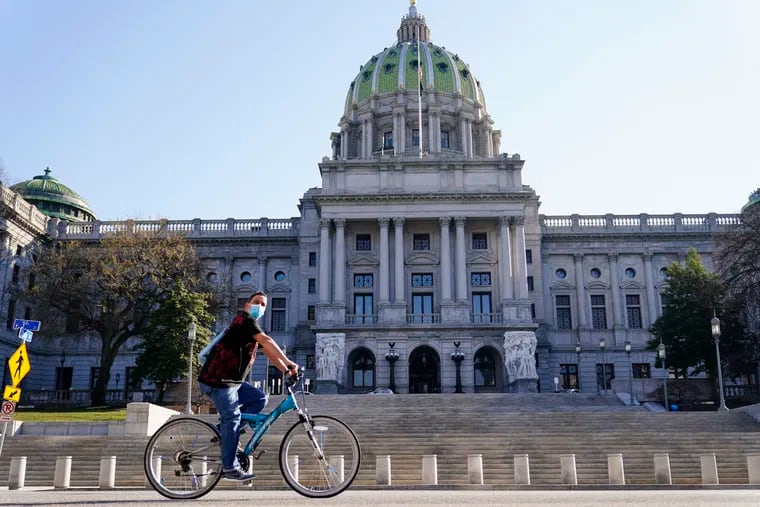 A cyclist rides past the Pennsylvania Capitol in Harrisburg. School districts and parents have sued the state over education funding.
