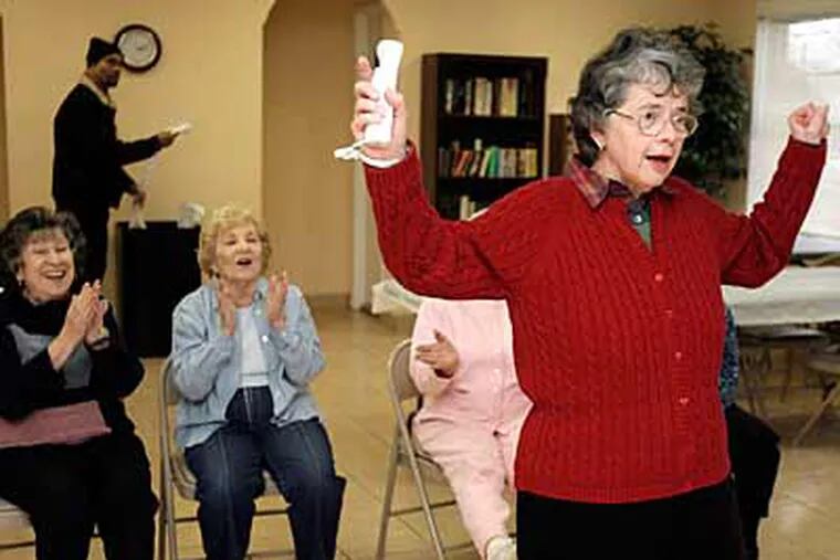 At the Towers at Windsor Place, Elaine Procida is cheered for a Wii strike. In the region, one in five people will be over 65 in 2025. (Akira Suwa / Staff Photographer)