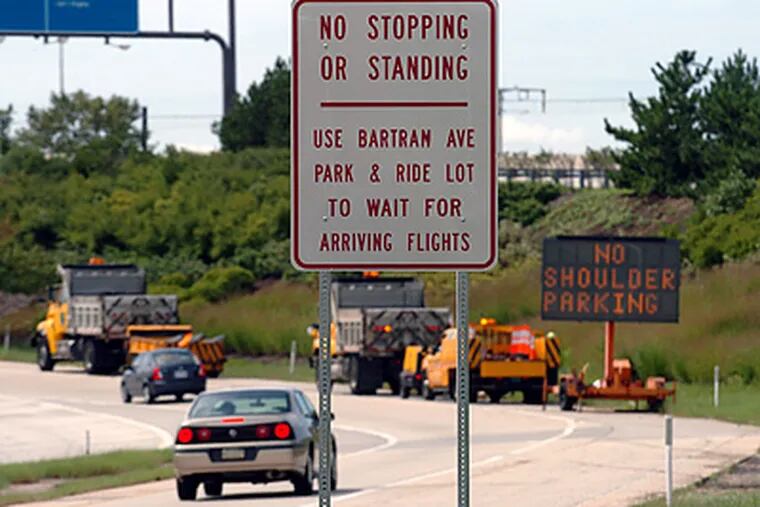 One of the signs on the airport road heading to the arrivals area of Philadelphia International Airport encouraging motorists to use the Bartram Ave park and ride lot. (Clem Murray/Staff Photographer)