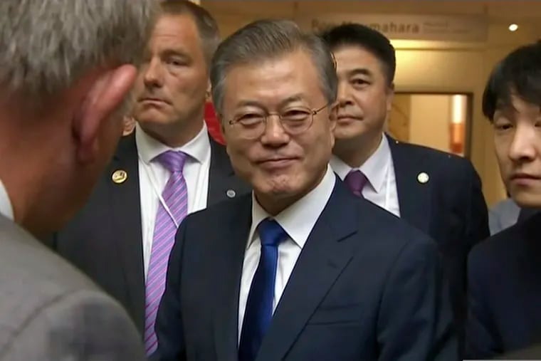 In this image made from a video, South Korean President Moon Jae-in, center, prepares to leave after a wreath laying ceremony at the Auckland War Memorial Museum in Auckland, New Zealand Monday, Dec. 3, 2018. Moon says U.S. President Donald Trump told him he has a "very friendly view" of North Korean leader Kim Jong Un and wants to grant his wishes if he denuclearizes. (TVNZ via AP)