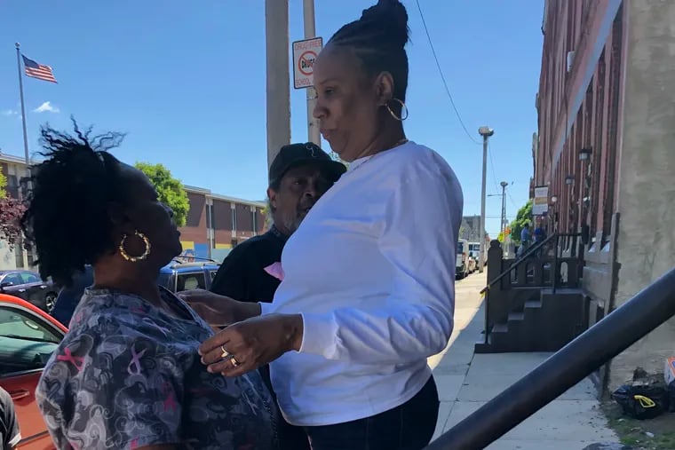 Sonjah Thrower, 54, in white shirt, the mother of gunshot victim Sharita Hardy, 35, greets neighbors on her front steps on Diamond Street on Friday, May 24, 2019. Hardy was shot and injured at the end of the block, at 16th and Diamond Streets, the previous night.
