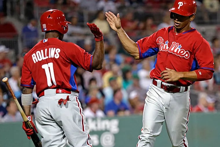 Cesar Hernandez is greeted by Jimmy Rollins (11) after scoring on a ground rule double by Ben Revere in the fifth inning of an exhibition baseball game in Fort Myers, Fla., Saturday, March 15, 2014. (Gerald Herbert/AP)