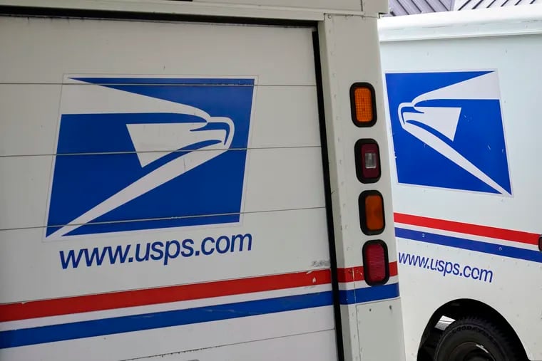 Mail delivery vehicles are parked outside a post office in Boys Town, Neb in August.
