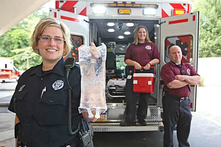 Emergency workers (from left) Kristin Buchholtz, with chilled saline; Jessica DiIenno, carrying cooler; and Chris Caruso are prepared to begin therapeutic hypothermia to treat cardiac arrest. (Michael Bryant/Staff)