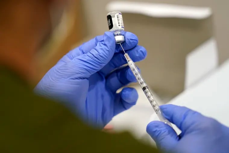 A healthcare worker fills a syringe with the Pfizer COVID-19 vaccine. (AP Photo/Lynne Sladky, File)