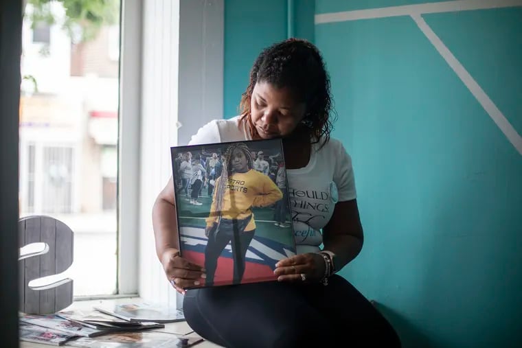 Tamika Valentine, 46, of Horsham, holds a framed photo of her daughter, Tianna Valentine-Eatman, 23, while sitting inside her daughter's hair salon, Salon Style and Grace, on Tuesday, July 23, 2019. "I have to keep her name relevant," she said of her daughter. "Her community was everything to her. Her family was everything to her. She always wanted to give back and she always wanted people to know that they were important."