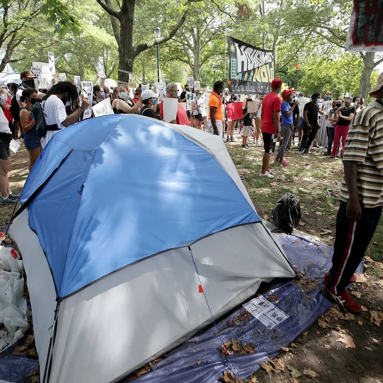 A crowd gathers during a press conference at a homeless encampment in a park on the Benjamin Franklin Parkway in 2020.