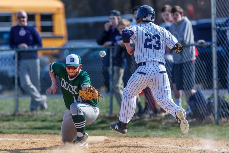 Dock Mennonite Academy first baseman Mike Moyer mishandles an infield throw, allowing Holy Ghost Prep's Evan Wilson (23) to reach first base safely and driving in a run to score during their game on April 4, 2019.