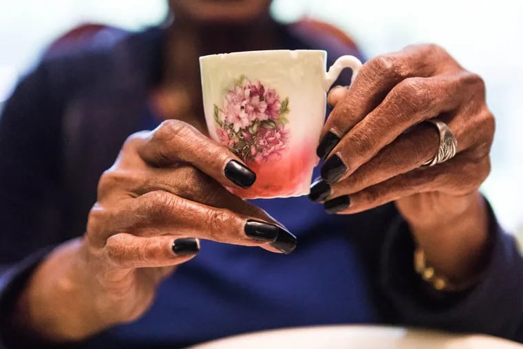 Willie Mae Lee holds up a cup from her fine china and glassware collection in her Laverock, Pa., home. This painted cup had been part of her mother-in-law’s collection.