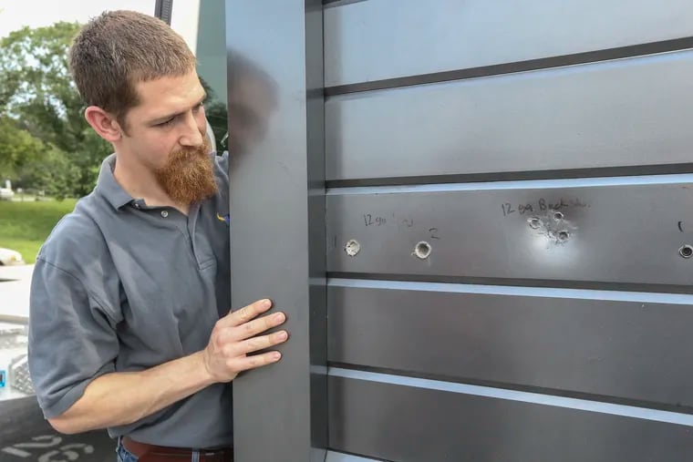 Compass Ironworks' George Settle with the test panel that stopped 12-gauge shotgun slugs and buckshot, at Compass Ironworks in western Chester County.