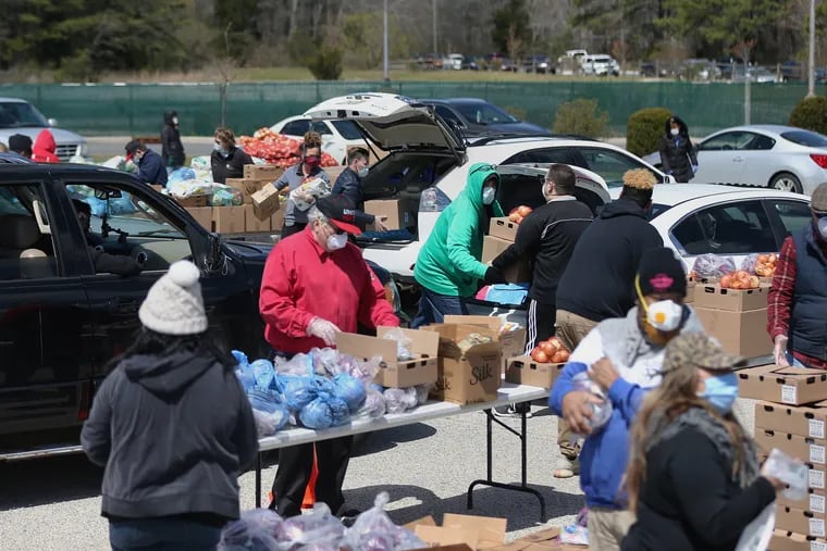 Casino workers and food bank volunteers distribute food for casino workers at Harbor Square in Egg Harbor Township, N.J., on Wednesday, April 22, 2020. Hundreds of cars lined up to receive food at the event, which was organized by Unite Here Local 54 and the Community Food Bank of New Jersey.