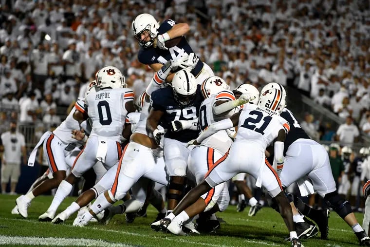 Penn State's Tyler Warren (44) dives over Auburn linebacker Owen Pappoe (0) to score a third-quarter touchdown in State College, Pa., on Saturday, Sept.18, 2021.