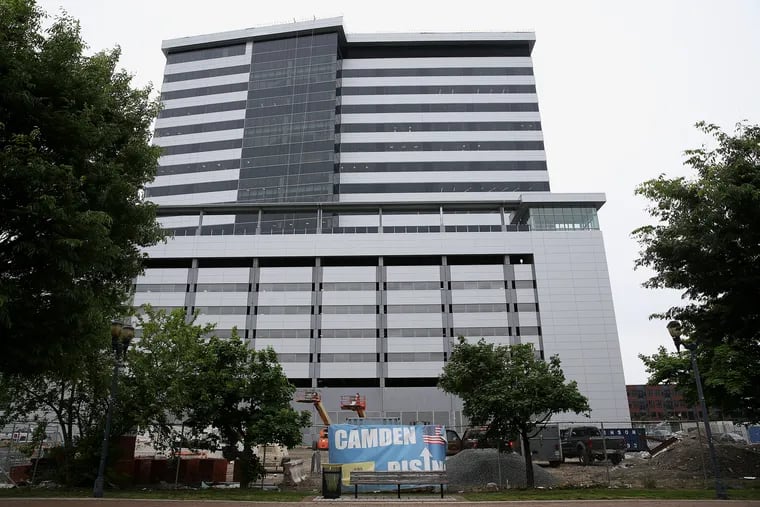 A banner reads "Camden Rising" outside the new high-rise office tower on the waterfront in Camden, N.J., on May 9, 2019. The project involved $245 million in tax breaks, including $79 million for NFI.