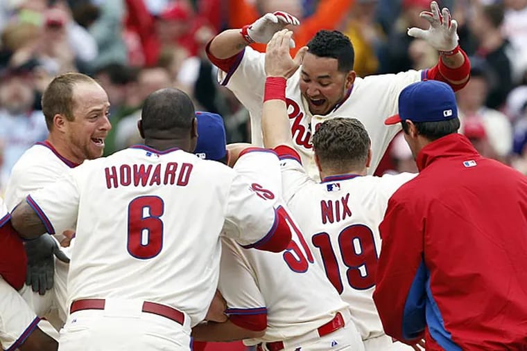 Freddy Galvis leaps into a pile of his Phillies teammates after hitting a walkoff home run against the Reds on Sunday. (David Maialetti/Staff Photographer)