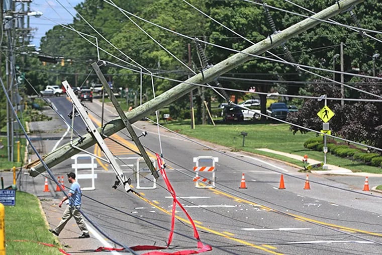 A power line over Harmony Road in Gibbstown, the pole snapped in half by the storm. Damage is in the millions, but not enough yet for a federal disaster declaration. (MICHAEL BRYANT/Staff
Photographer)