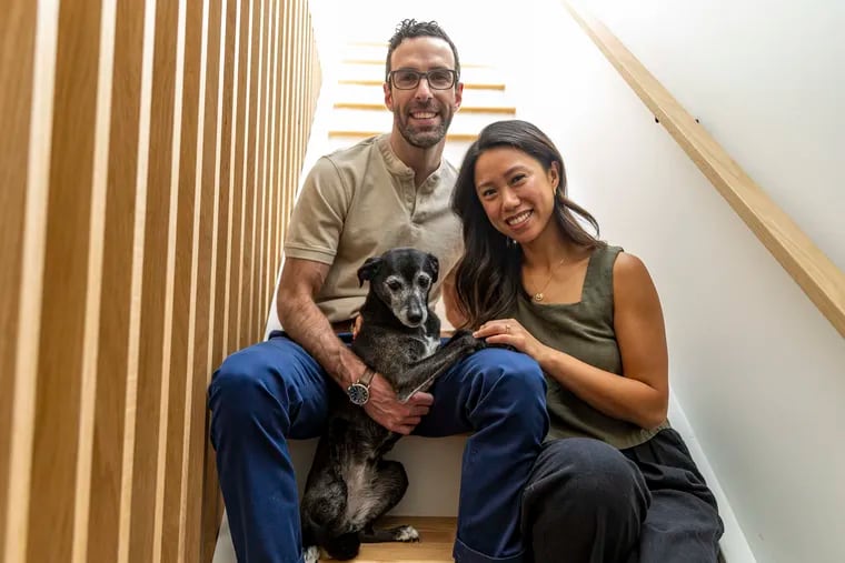 Irene Guo, 35,  and Mark Licurse, 39, of Graduate Hospital, Pa., pose for a portrait with their dog Mochi, 12, in their home they renovated in Philadelphia, Pa., on Thursday, Aug., 31, 2023.