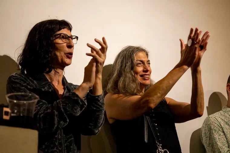 Robin Casey (left) and Angela Babin, both of New York, applaud violinist Lara St. John during a solidarity concert for the violinist in Manhattan Friday night.
