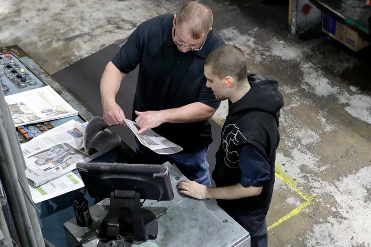In this April 11 photo, pressmen Kit Stover, of Richmond, Mass. (left) and Lukus Ladeinde, of Pittsfield, Mass. check for correct registration of print from a sample of a newspaper fresh off the press at The Berkshire Eagle newspaper, in Pittsfield, Mass. The paper now features a new 12-page lifestyle section for Sunday editions, a reconstituted editorial board, a new monthly magazine, and the newspaper print edition is wider. That level of expansion is stunning in an era where U.S. newspaper newsroom employment has shrunk by nearly half over the past 15 years.