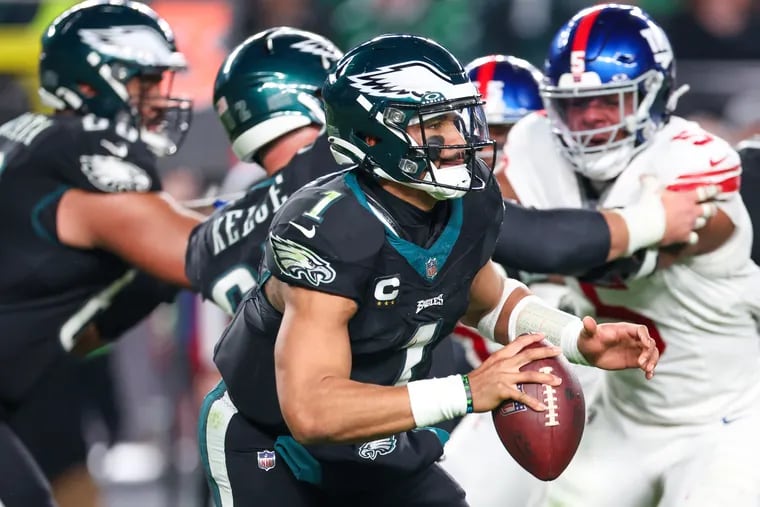 Eagles quarterback Jalen Hurts looks for an open receiver against the Giants, connecting with A.J. Brown on the play.