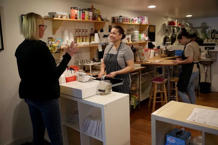 Shop owner Wanda Lozada, right, talks with a regular customer, Mimi Hall, left, at Peace of Cake in Camden, NJ on May 14, 2018.  DAVID MAIALETTI / Staff Photographer