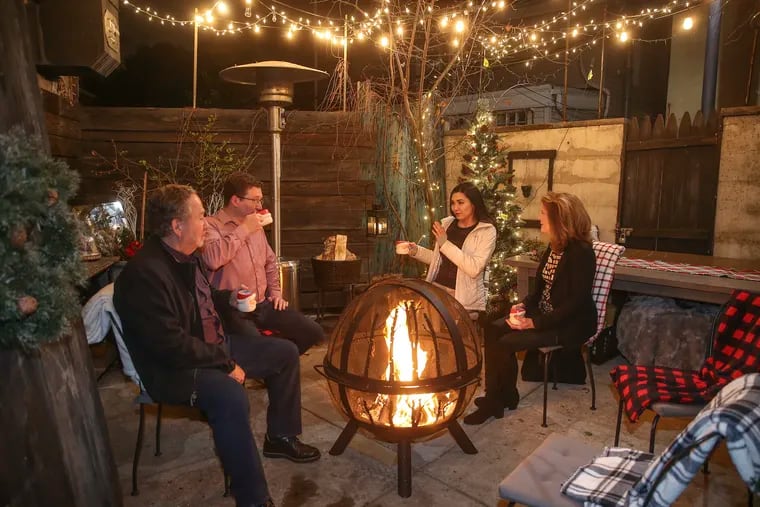 Laurel restaurant guests are invited to the outdoor garden after dinner on Passyunk Avenue, (l-r) Tim Casey, Wilmington Delaware, Michael Casey, Philadelphia, Melissa Phan and Diane Casey Wilmington Delaware all enjoy a "Angry Santa Drink" a warm rum drink, Thursday, December 5, 2019.