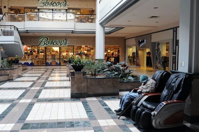 A Granite Run Mall visitor sleeps in one of the reclining chairs outside Boscov's, one of only 30 stores still operating in the mall. ( CLEM MURRAY / Staff Photographer )