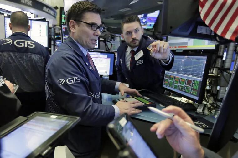 Specialists Robert Tuccillo (center) and Matthew Greiner work at their post on the floor of the New York Stock Exchange.