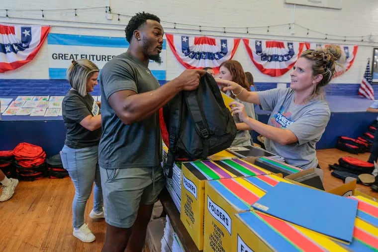 Eagles Nakobe Dean stuffing backpacks for a giveaway with help from Lauren Meredith for Backpack Blitz, Kids In Need Foundation at the Bridesburg Boys & Girls Club. Tuesday,  September 19, 2023