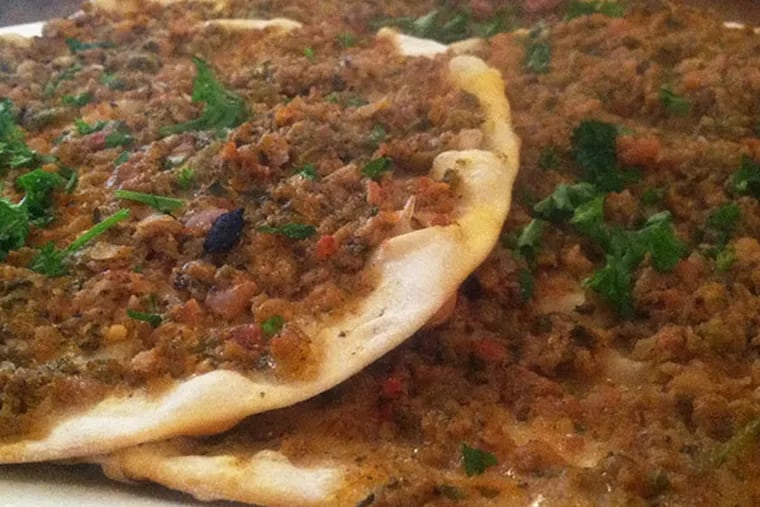 Turkish Lahmacun flatbreads topped with minced lamb from Leziz Turkish Cuisine. (Craig LaBan / Staff)