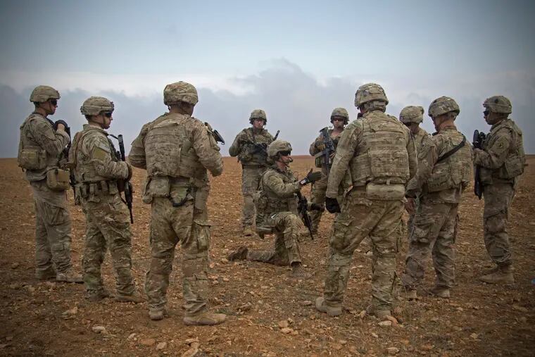 In this Nov. 7, 2018, photo released by the U.S. Army, U.S. soldiers gather for a brief during a combined joint patrol rehearsal in Manbij, Syria.