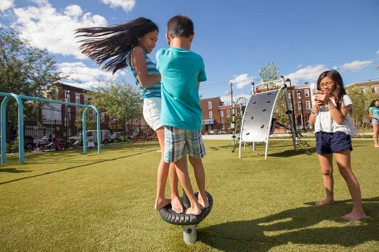 Cousins Jillian Pham (from left), 13, Zachary Dinh, 8, and Brianna Dinh, 11, play together at Di Silvestro Playground in the Point Breeze neighborhood of South Philadelphia.