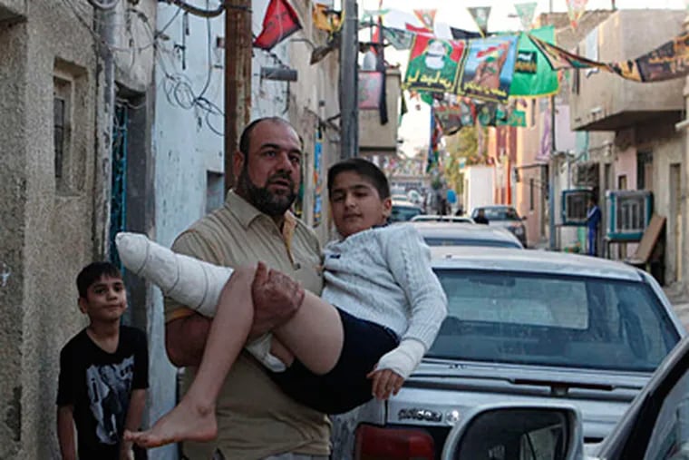 Ali Hassan Wali , 13, who lost a foot when a car bomb exploded, is carried to a doctor's visit by his uncle. He said he thinks his country will get better &quot;after we get rid of all the terrorists who make the explosions.&quot; KARIM KADIM / Associated Press