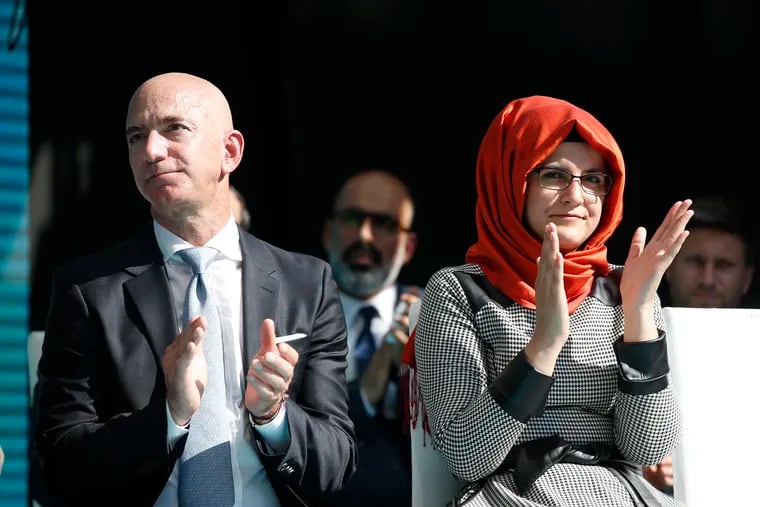 Amazon and Washington Post owner Jeff Bezos, left, and Hatice Cengiz, right, the fiancee of slain Saudi journalist Jamal Kashoggi. at a vigil.