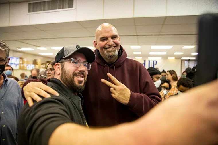 Pennsylvania Lt. Gov. John Fetterman, right, takes a selfie Michael Silver, of Paoli, during a campaign stop last weekend in Plymouth Meeting. As he closes in on the Democratic Senate nomination in Pennsylvania, Fetterman doesn’t have supporters so much as full-on fans.