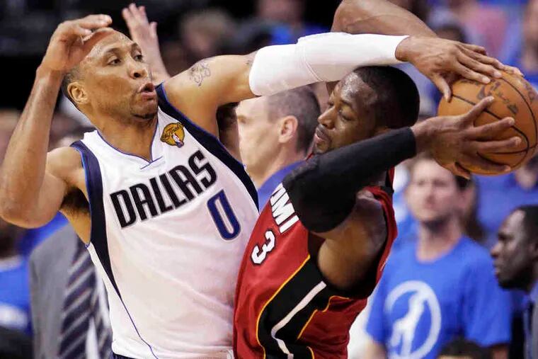 Dallas defensive specialist Shawn Marion bodies up on Dwyane Wade. Wade scored 32 points in the Heat's losing effort.
