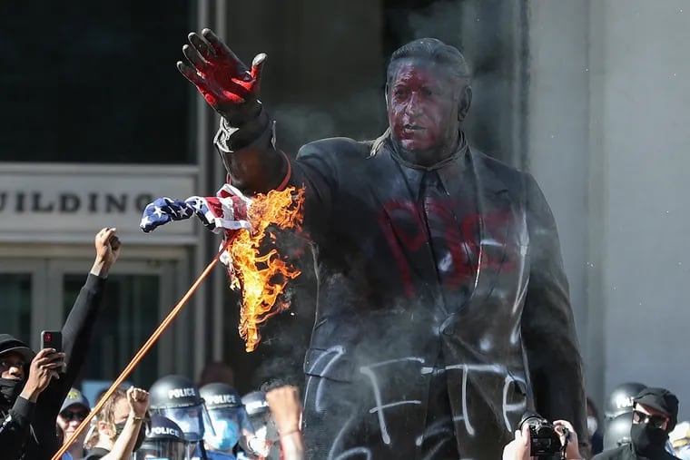Protesters attempt to burn and bring down the Frank Rizzo statue outside of the MSB building in Philadelphia after a protest against the death of George Floyd on Saturday, May 30, 2020.