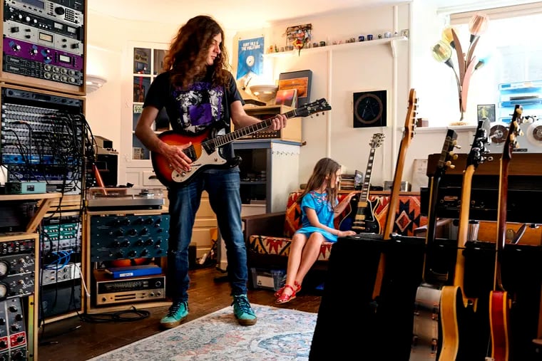 Kurt Vile in his basement studio at his home in Mt. Airy June 13, 2022 with his daughter Delphine. His record label sent him a cheesesteak sculpture in honor of his song "Pretty Pimpin" being streamed 100 million times.