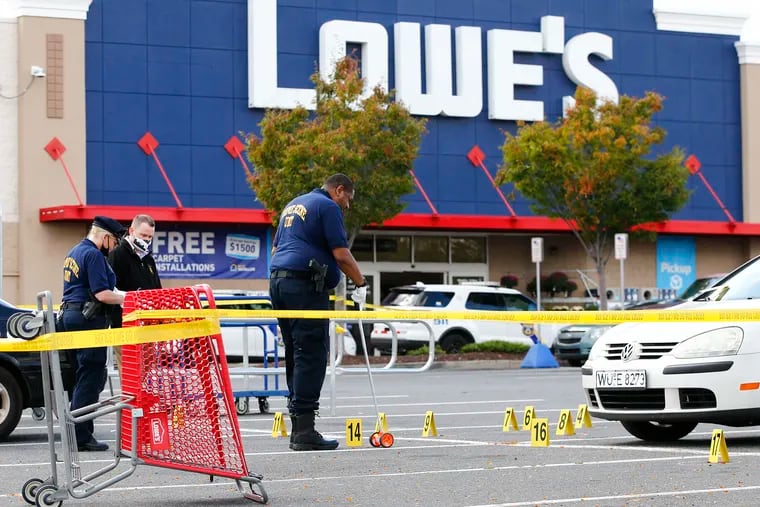 Philadelphia Police Crime Scene Unit members investigate a shooting in the parking lot of the Lowe's Home Improvement store along Columbus Boulevard in South Philadelphia on Monday.